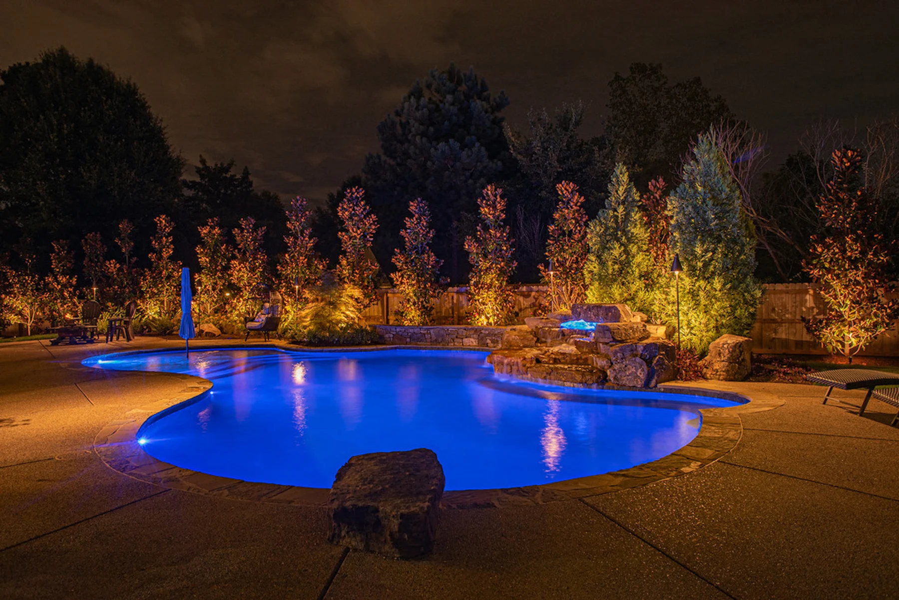 Backyard lit up with trees showing off a beautiful backyard